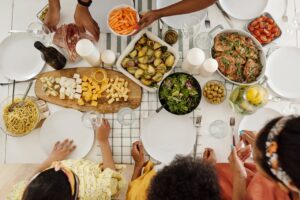Overhead shot of family enjoying a diverse meal with assorted dishes, olives, and salad.